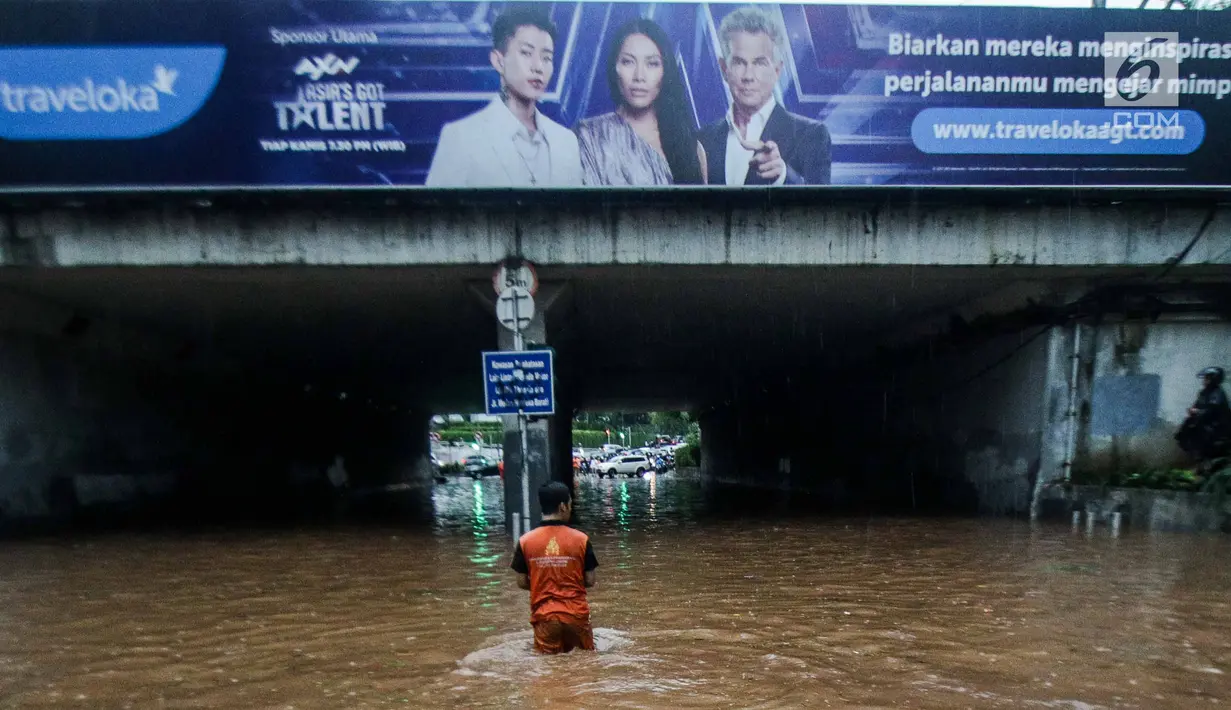 Petugas mengecek kondisi air yang membanjiri terowongan Dukuh Atas, Jakarta, Senin (11/12). Hujan lebat yang mengguyur ibu kota mengakibatkan genangan hingga satu meter di lokasi tersebut. (Liputan6.com/Faizal Fanani)