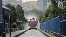 Petugas Damkar saat menyemprotkan cairan disinfektan di kawasan Terminal bus dan Blok M Square, Jakarta, Selasa (23/6/2020). Penyemprotan cairan disinfektan tersebut bertujuan untuk mencegah penyebaran COVID-19. (Liputan6.com/Faizal Fanani)