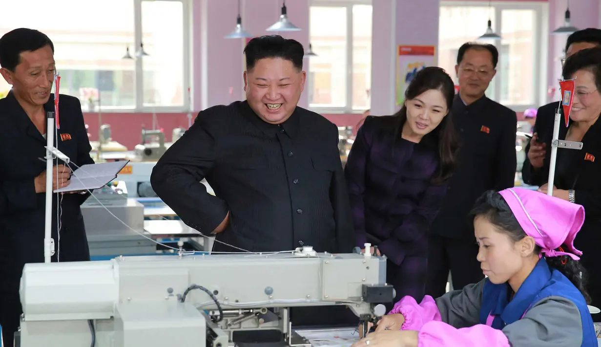 Pemimpin Korea Utara Kim Jong-Un melihat pekerja menjahit pola sepatu saat saat mengunjungi pabrik sepatu Ryuwon di Pyongyang 19 Oktober 2017. (AFP Photo/KCNA Via KNS/Str/South Korea Out/Republic Of Korea Out)