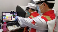 Anggota tim pakar medis China, Chen Huai (depan) dan Ai Hexu memeriksa citra tomografi terkomputasi dada di Baghdad, Irak, Senin (30/3/2020). Sejak 7 Maret lalu, tujuh pakar medis China bekerja sama dengan tenaga ahli lokal di Irak untuk memerangi epidemi virus corona COVID-19. (Xinhua)