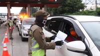 Petugas Satpol-PP saat melakukan pengecekan SIKM  terhadap kendaran yang akan memasuki  Jakarta di gerbang tol Cikupa, Rabu (27/5/2020). Masyarakat wajib menunjukan SIKM bila ingin kembali atau memasuki Jakarta, Hal tersebut bertujuan untuk menekan penyebaran Covid-19. (Liputan6.com/Angga Yuniar)