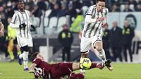 Penyerang Juventus Federico Chiesa mencoba menghindari tantangan meluncur dari gelandang Torino Samuele Ricci pada pekan ke-24 Liga Italia di Stadion Allianz, Rabu (1/3/2023) dini hari WIB. Empat gol I Bianconeri dilesakkan oleh Juan Cuadrado, Danilo, Gleison Bremer, Adrien Rabiot . (Tano Pecoraro/LaPresse via AP)
