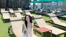 Karina membagikan potret dirinya saat bersantai di negeri seribu pagoda, Thailand yang berhasil membuat para penggemar terkesima. Perpaduan warna kulit dengan long white dress membuat dirinya seperti malaikat. [@aespa_official]