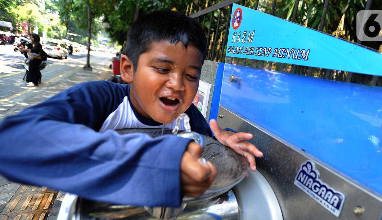 Seorang anak minum dari Keran Air Siap Minum (KASM) yang terpasang di dekat Pintu 2 Kebun Raya Bogor, Jawa Barat, Minggu (6/10/2019). Pemkot Bogor melalui PDAM Tirta Pakuan membuat KASM di pendestrian Jalan Ir H Djuanda untuk menekan angka konsumsi botol dan gelas plastik. (merdeka.com/Arie Basuki)