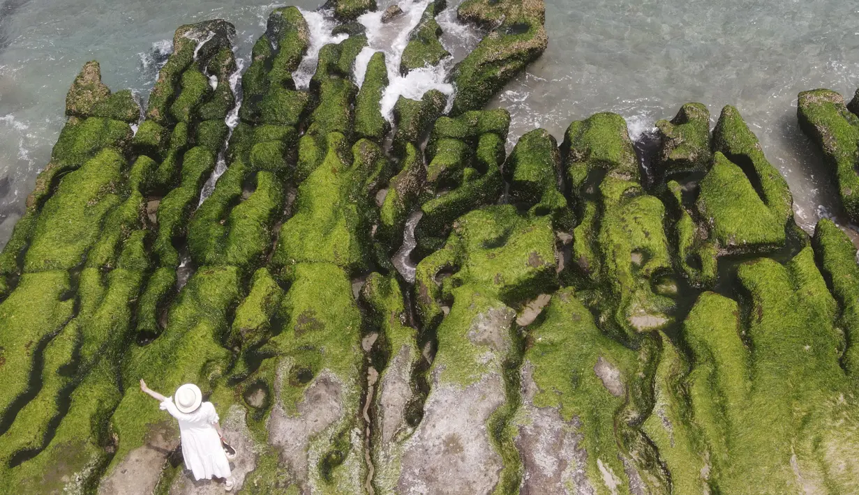Pemandangan dari udara menunjukkan seorang turis lokal mengunjungi Laomei Green Reef di Distrik Shimen Kota New Taipei (12/4/2022). Laomei Green Reef adalah salah satu tempat paling indah di sepanjang Pantai Utara Taiwan. (AFP/Sam Yeh)
