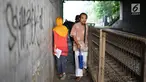 Pejalan kaki melintasi jalan setapak di sekitar Stasiun Cawang, Jakarta, Kamis (9/5). Meskipun sempit, jalan setapak tersebut masih menjadi pilihan sebagian pejalan kaki untuk menyeberangi Jalan Gatot Soebroto, dibanding harus melewati JPO yang jaraknya lebih jauh. (Liputan6.com/Immanuel Antonius)
