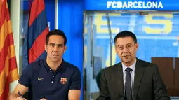 Claudio Bravo (kiri) bersama presiden Barcelona, Josep Maria Bartomeu, saat penandatanganan kontrak di Stadion Camp Nou. Selama empat tahun,Claudio Bravo akan bermain bersama Barcelona. (AFP PHOTO/FC BARCELONA/Miguel Ruiz)