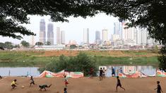 Sejumlah anak asyik bermain sepak bola di bantaran kali Banjir Kanal Barat (BKB), Jakarta. Minimnya lahan bermain tak menyurutkan semangat mereka untuk berolahraga sekaligus bersenang-senang dengan sepak bola. (bola.com/M Iqbal Ichsan)