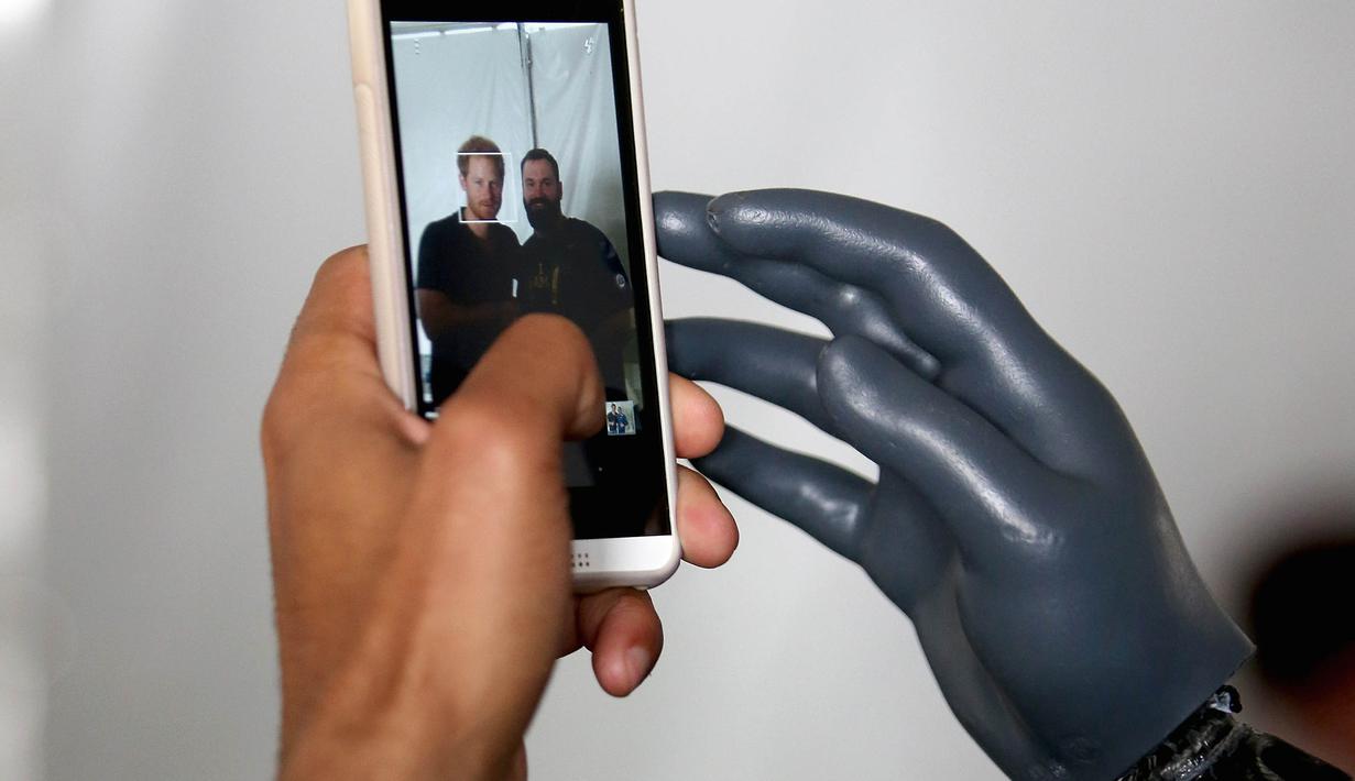 Seorang peserta melihat fotonya bersama Pangeran Harry di handphone miliknya sebelum berlaga pada kejuaraan Invictus Games Orlando 2016 di ESPN Wide World of Sports,Orlando, Florida, (10/5/2016). (Chris Jackson/Getty Images for Invictus/AFP)
