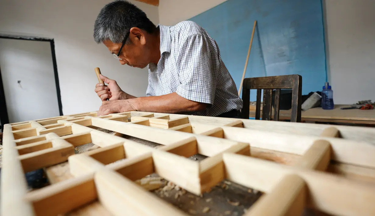 Pekerja membuat komponen kayu dengan teknik tradisional untuk rumah kuno di Distrik Xiangdu, Kota Xingtai, China, 14 Juli 2020. Pemerintah setempat tahun ini menjalankan proyek renovasi rumah kuno untuk merevitalisasi rumah-rumah tua dan memelihara warisan budaya arsitektur kuno. (Xinhua/Zhu Xudong)