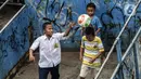 Sejumlah anak bermain sepak bola dalam bak truk di kawasan Cengkareng, Jakarta, Rabu (23/2/2022). Minimnya lahan bermain di kawasan tersebut membuat anak-anak memanfaatkan tempat yang bukan semestinya untuk bermain bola. (Liputan6.com/Johan Tallo)
