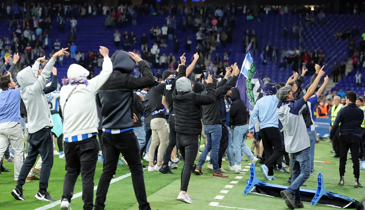 Suporter Espanyol bereaksi menyerbu lapangan atas kemenangan Barcelona setelah laga tandang pekan ke-34 La Liga 2022/2023 di RCDE Stadium, Senin (15/5/2023) dini hari WIB. (Photo by Lluis GENE / AFP)