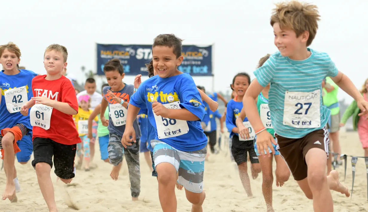 Semangat anak-anak saat mengikuti 'Tot Trot' selama Nautica Malibu Triathlon di Pantai Zuma di Malibu, California (14/9). (Noel Vasquez / Getty Images untuk Nautica / AFP)