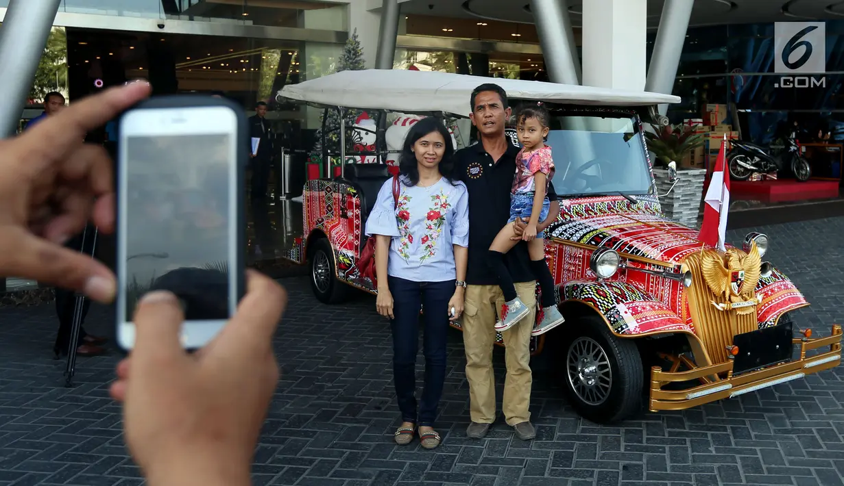 Warga berfoto bersama mobil bercorak Ulos Mandailing yang akan digunakan acara ngunduh mantu Kahiyang-Bobby di Medan, Senin (20/11). (Liputan6.com/JohanTallo)