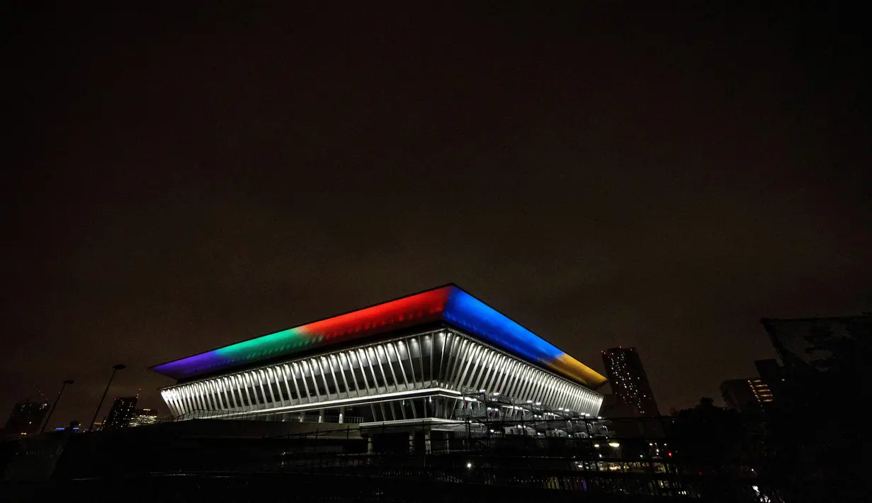 Gambar menunjukkan Tokyo Aquatics Center, tempat acara renang, menyelam, dan renang artistik, tampak disoroti warna-warni cahaya Olimpiade untuk menandai 100 hari jelang pembukaan Olimpiade Tokyo 2020 di Tokyo, Jepang, pada 14 April 2021. (Behrouz MEHRI / AFP)