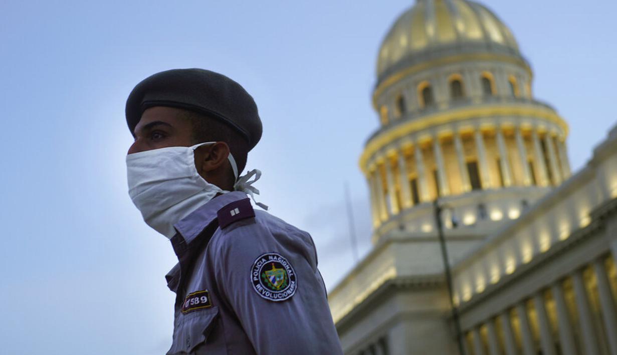 Polisi mengenakan masker saat berjaga dekat Capitol selama penerapan jam malam di Havana, Kuba, Selasa (1/9/2020). Otoritas Kuba menerapkan lockdown selama 15 hari di Havana untuk keluar dari penularan COVID-19 tingkat rendah tetapi terus-menerus. (AP Photo/Ramon Espinosa)