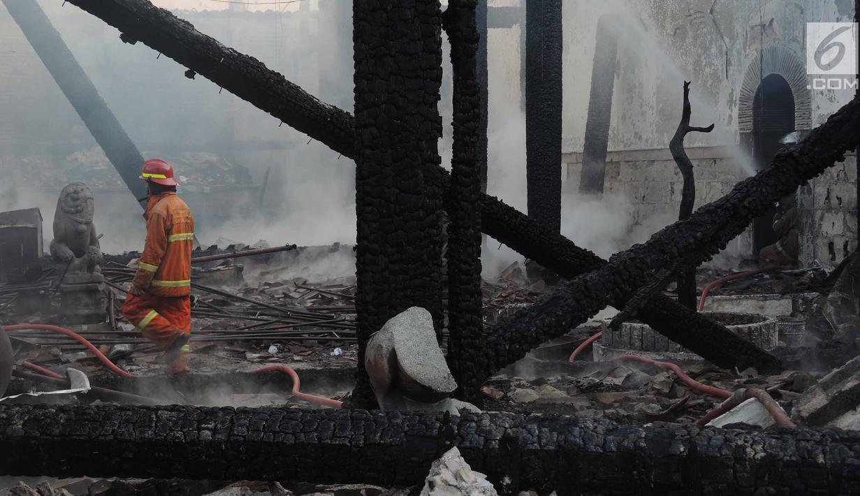 Petugas damkar melihat sisa puing kebakaran yang melanda kompleks Kelenteng Tay Kak Sie di Gang Lombok, Semarang, Kamis (21/3). Bangunan yang terbakar merupakan rumah abu yang berada satu kompleks dengan bangunan utama kelenteng. (Liputan6.com/Gholib)