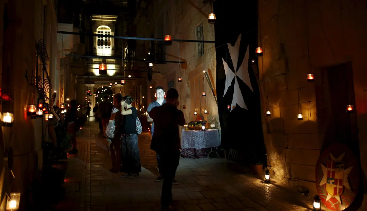 Para wisatawan menikmati keindahan lilin - lilin saat digelarnya festival Birgu di Malta, Sabtu (10/10/2015). Festival ini bertujuan memberikan sentuhan magis terhadap kota yang dulunya merupakan rumah pertama Knights of St John. (REUTERS/Darrin Zammit)