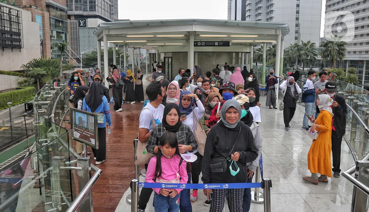 Sejumlah warga antre di anjungan Halte Transjakarta Bundaran HI , Jakarta, Minggu (16/10/2022). Anjungan yang berada di lantai dua Halte Transjakarta Bundaran HI ini dapat menampung 20 orang dan menjadi spat foto baru dengan latar belakang Patung Selamat Datang dan air mancur Bundaran HI. (Liputan6.com/Angga Yuniar)