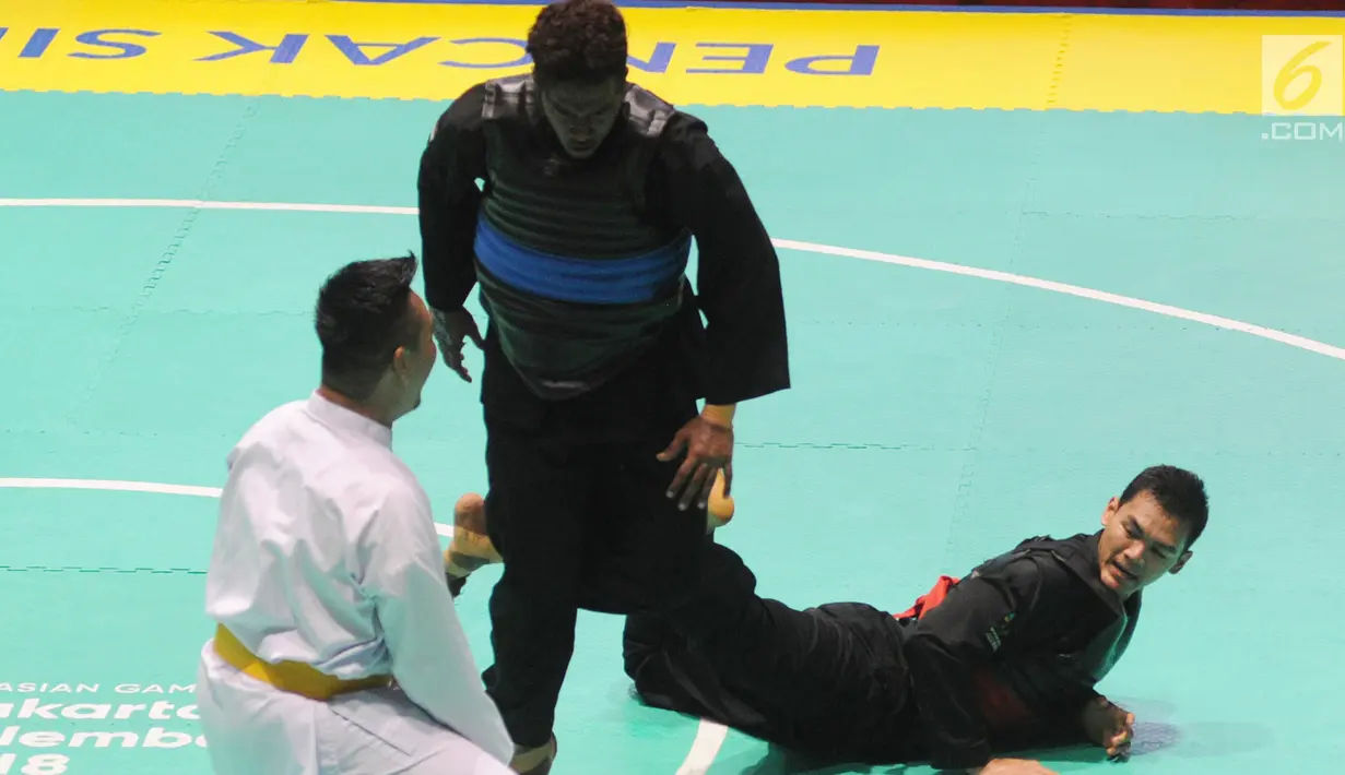 Pesilat Indonesia Aji Bangkit Pamungkas (merah) bertanding melawan pesilat Singapura Sheik Alauddin (biru) dalam babak final Kelas I Putra Asian Games 2018 di TMII, Jakarta, Senin (27/8). Aji berhasil merebut medali emas. (Merdeka.com/Arie Basuki)