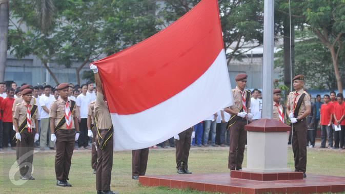 Petugas melakukan pengibaran bendera pada upacara peringatan 87 tahun Sumpah Pemuda di Lapas Narkotika Klas II A Cipinang, Jakarta, Rabu (28/10). Rencananya, upacara yang diikuti 2600 napi ini untuk memecahkan rekor MURI. (Liputan6.com/Gempur M Surya)