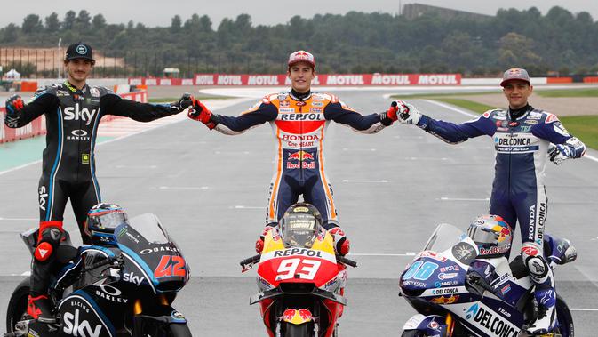 Juara Dunia MotoGP Marc Marquez (tengah) berpose bersama Juara Dunia Moto2 Francesco Bagnaia (kiri) dan Juara Dunia Moto3 Jorge Martin (kanan) usai Grand Prix Valencia di sirkuit Ricardo Tormo, Cheste, Spanyol, Minggu (18/11). (AP Photo/Alberto Saiz)