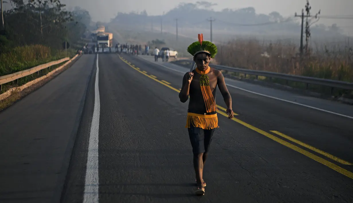 Masyarakat suku Kayapo membawa tongkat saat memblokir jalan raya utama Trans-Amazonian di Negara Bagian Para, Brasil (17/8/2020). (AFP Photo/Carl De  Souza)