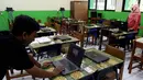 Petugas mengecek kesiapan laptop dan ruang untuk Ujian Nasional Berbasis Komputer di SMP N 34 Pademangan, Jakarta Utara, Minggu (22/4). UNBK SMP 2018 akan berlangsung mulai besok Senin (23/4). (Liputan6.com/Johan Tallo)