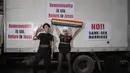Peserta parade penyuka sesama jenis berfoto dengan poster slogan anti-gay dalam acara 'Gay Pride' di Seoul, Korea Selatan (15/7). Sekitar 10.000 warga korsel turun ke jalan untuk merayakan parade bagi kaum LGBT. (AFP Photo/Ed Jones)