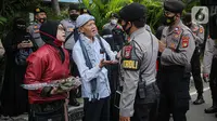 Aparat kepolisian membujuk peserta aksi Reuni 212 untuk membubarkan diri di Jalan Abdul Muis, Jakarta, Kamis (2/12/2021). Tindakan ini diambil demi menghindari terjadinya kerumunan massa. (Liputan6.com/Faizal Fanani)
