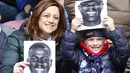 Ibu dan anak memegang poster pemain Napoli, Kalidou Koulibaly pada laga  Serie A Liga Italia di San Paolo stadium, Minggu (7/2/2016).  Kalidou mendapat dukungan atas tindakan rasis dari fans Lazio. (AFP/Carlo Hermann)