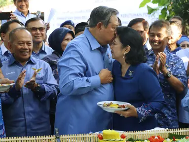 Ketua Umum Partai Demokrat Susilo Bambang Yudhoyono mencium istrinya, Ani Yudhoyono saat potong tumpeng dalam perayaan HUT Partai Demokrat ke-16 di Cikeas, Jawa Barat, Sabtu (9/9). (Liputan6.com/Angga Yuniar)