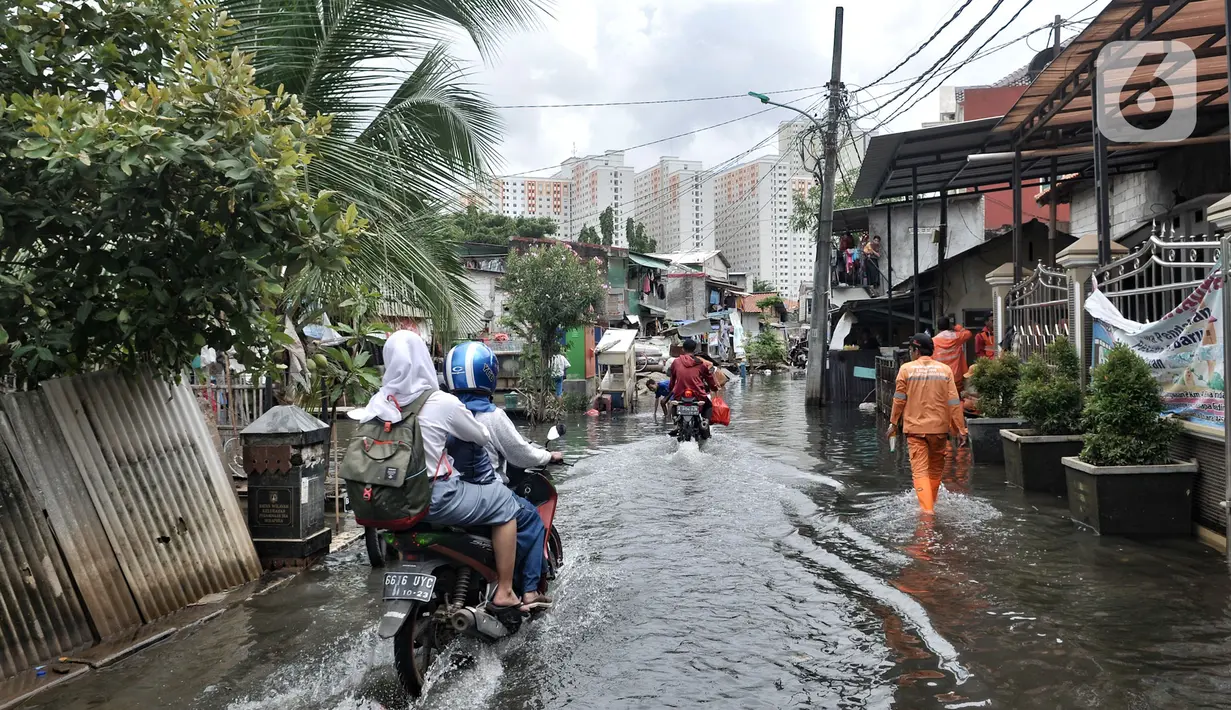 Pengendara motor melintasi banjir yang masih merendam Kampung Rawa Indah, Jakarta Utara, Senin (24/2/2020). Kampung yang terletak di dua kelurahan, yakni Sukapura dan Pegangsaan Dua tersebut masih terendam banjir hingga sore ini dengan ketinggian air 30-50 cm. (merdeka.com/Iqbal S Nugroho)