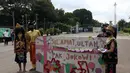 Demonstran melakukan aksi teatrikal saat unjuk rasa di kawasan Bundaran Patung Kuda Arjuna Wijaya, Jakarta, Senin (21/6/2021). Aksi yang dilakukan bertepatan dengan ulang tahun Presiden Joko Widodo ini sebagai bentuk kecaman dan penolakan terhadap revisi UU Minerba. (Liputan6.com/Angga Yuniar)