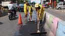 Petugas Bina Marga Pasar Minggu menambal jalan yang rusak di Jalan Raya Ragunan, Jakarta, Senin (22/4). Petugas mengaku bahwa keberadaan beton pembatas jalan justru membuat jalan di kawasan tersebut selalu rusak setiap hujan deras karena menimbulkan genangan air. (Liputan6.com/Immanuel Antonius)