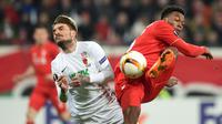 Duel antara pemain Augsburg, Konstantinos Stafylidis (kiri), dengan pemain Liverpool, Daniel Sturridge, pada laga leg pertama 32 besar Liga Europa, di WWK Arena, Augsburg, Jerman, Jumat (19/2/2016) dini hari WIB. (AFP/Christof Stache)