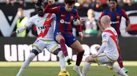 Penyerang Barcelona Joao Felix berebut bola dengan pemain Rayo Vallecano Pathe Ciss dan Isi Palazon&nbsp;dalam pertandingan Liga Spanyol di&nbsp; Estadio de Vallecas, Sabtu, 25 November 2023. (OSCAR DEL POZO / AFP)