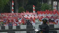 Pengendara motor melintasi pedagang bendera di kawasan Pasar Jatinegara, Jakarta, Rabu (14/8/2019). Pedagang musiman memajang beragam jenis aksesoris seperti bendera merah putih, umbul-umbul dan lambang Garuda untuk perayaan HUT ke-74 RI pada 17 Agustus 2019 mendatang. (merdeka.com/imam buhori)