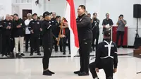 Menpora RI Dito Ariotedjo menyerahkan bendera Merah Putih kepada Chef de Mission (CdM) Kontingen Indonesia Anindya Novyan Bakrie dalam upacara Pengukuhan Kontingen Indonesia untuk Olimpiade Paris 2024 di Auditorium Wisma Kemenpora, Jakarta, Rabu (10/7/2024). Sebanyak 29 atlet akan mewakili Indonesia untuk berlaga dalam Olimpiade Paris 2024 pada 26 Juli hingga 11 Agustus 2024 mendatang. (Bola.com/Abdul Aziz)