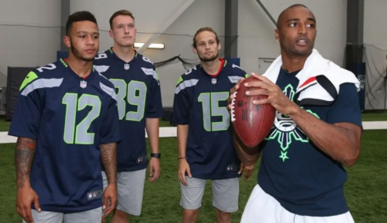 Bintang American Football dari klub Seattle Seahawks, Doug Baldwin, sedang memberi contoh melempar bola kepada para pemain MU. (Manutd.com)