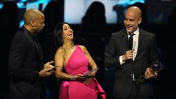 Pelatih Manchester City, Pep Guardiola (kanan) berbincang dengan para pembawa acara saat memenangkan penghargaan pelatih terbaik FIFA 2023 ada acara Best FIFA Football Awards yang berlangsung di Eventim Apollo, Hammersmith, London, Senin (15/01/2024) waktu setempat. (AFP/Adrian Dennis)