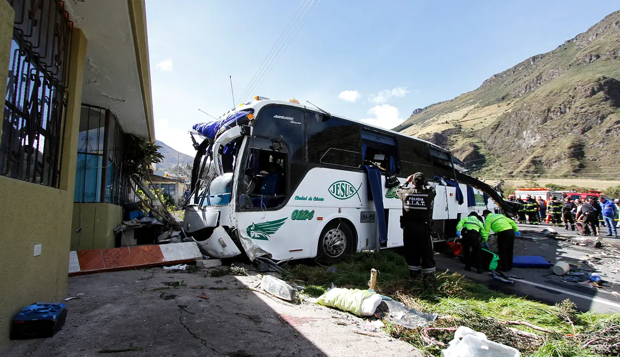 Polisi dan petugas penyelamat bekerja memindahkan bus pembawa turis asal Kolombia dan Venezuela di Pifo, Ekuador, Selasa (14/8). Polisi Ekuador menyatakan kedua kedutaan telah diberitahukan soal kecelakaan tersebut. (AP Photo/Carlos Noriega)