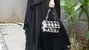 Penampilannya terlihat santun dengan gamis hitam dengan hijab syar'i dan bros emas di sebelah kanan [@ollaramlan]