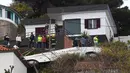Orang-orang melihat kondisi sebuah bus pariwisata berisi rombongan turis dari Jerman yang terguling di Kota Canico, Pulau Madeira, Portugal, Rabu (17/4). Warga setempat melaporkan bahwa cuaca baik-baik saja pada saat kecelakaan, yang terjadi di sore hari. (RUI SILVA / AFP)