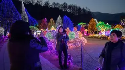 Gambar yang diambil 11 Januari 2020, pengunjung melihat tampilan beragam kerlip lampu di Garden of Morning Calm, sebelah timur Seoul di distrik Gapyeong, Korea Selatan. Festival cahaya tahunan tersebut dinikmati saat musim dingin, Desember sampai akhir bulan Maret. (Ed JONES / AFP)