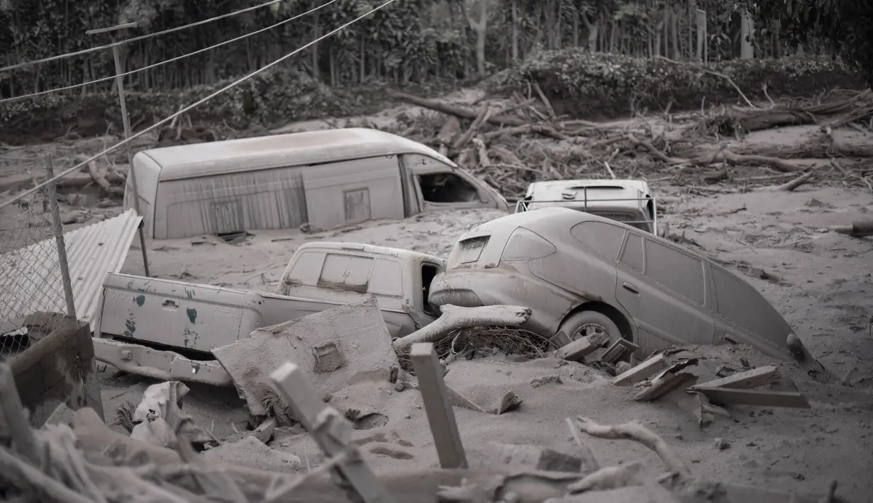 Sejumlah mobil rusak dan tertimbun abu usai terjadi letusan gunung berapi Fuego di San Miguel Los Lotes, Guatemala (4/6). Sebuah desa Escuintla dipenuhi abu setelah terjadi letusan gunung berapi Fuego. (AFP/Johan Ordonez)