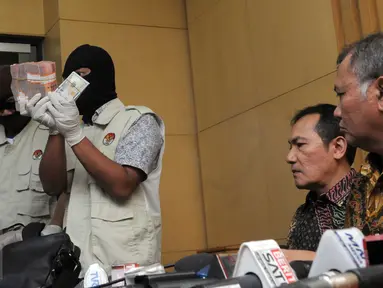Petugas KPK menunjukkan barang bukti yang diperoleh dari operasi tangkap tangan (OTT) terkait dugaan suap DPRD DKI Jakarta disaksikan pimpinan KPK, Jakarta, Jumat (1/4). (Liputan6.com/Helmi Afandi)