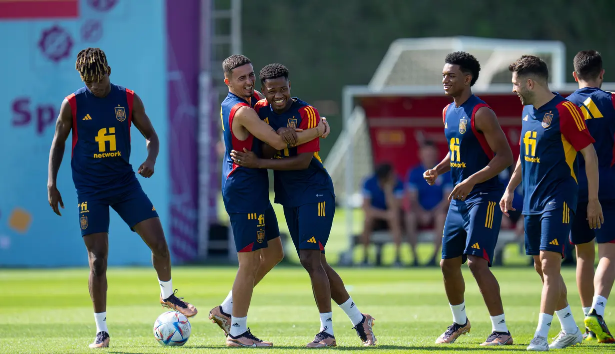 Pemain Spanyol Ansu Fati (tengah) dipeluk oleh Yeremy Pino (tengah kiri) saat berlatih bersama rekan setim mereka di Universitas Qatar, Doha, Qatar, Selasa (29/11/2022). Spanyol akan melawan Jepang dalam pertandingan Grup E Piala Dunia 2022 pada 1 Desember mendatang. (AP Photo/Julio Cortez)