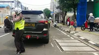Polantas memberhentikan mobil Toyota Fortuner hitam yang diduga menggunakan pelat nomor dinas Polri palsu di Jatinegara. (Istimewa)
