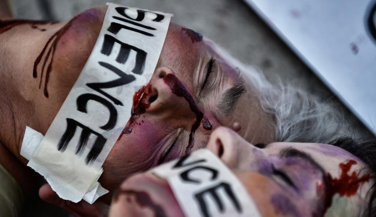 Aktivis Spanyol Jil Love dan aktivis Meksiko Julia Klug saat melakukan aksi di Mexico City, Meksiko (27/8). Dua aktivis ini tampil melakukan teatrikal dengan make-up wajah babak belur dan berlumuran "darah". (AFP Photo / Pedro Pardo)